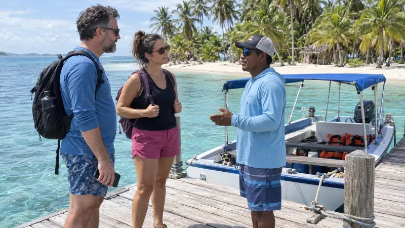Travelers discussing excursion arrangements beside a moored passenger boat at a palm-fringed San Blas island.