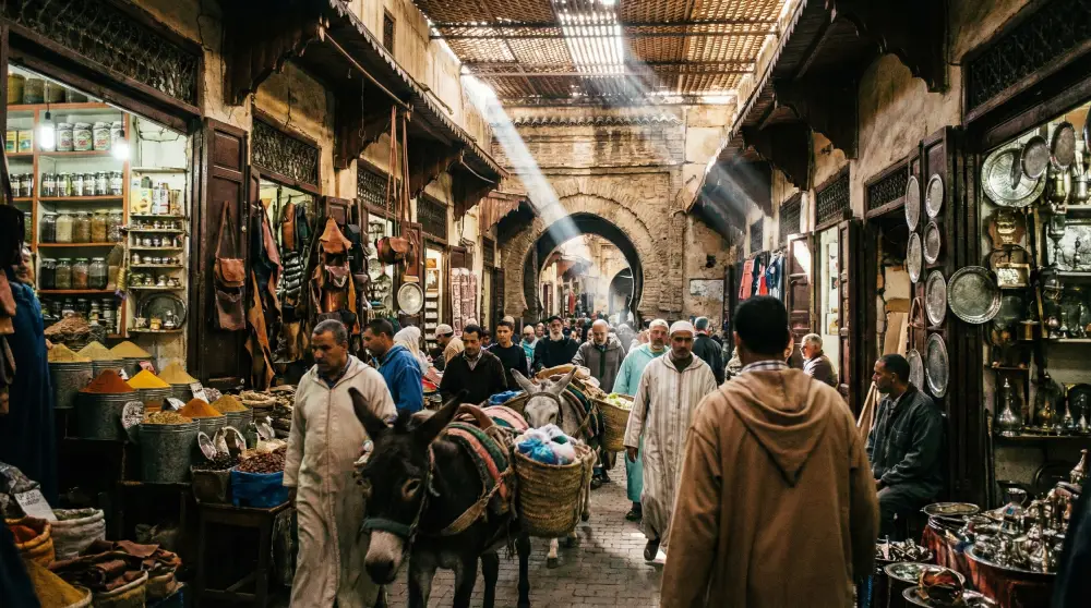 Crowded and winding alleyways inside the Fes Medina in Morocco, illustrating the complexity of navigation.