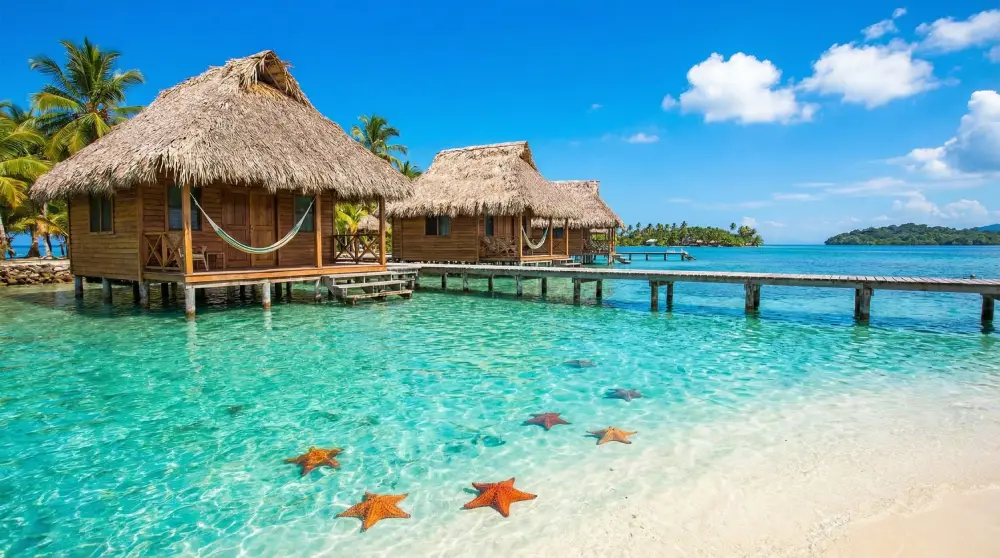 Crystal clear turquoise waters and overwater bungalows in Bocas del Toro, highlighting the sunny Caribbean microclimate in Panama.