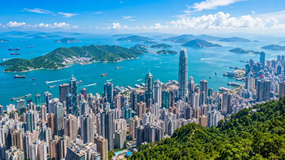 An aerial view showing the contrast between Hong Kong's dense urban skyscrapers and the lush green outer islands.