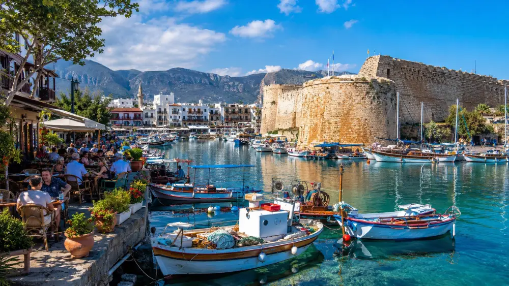 A bustling, sunny harbor in Kyrenia with boats and cafes.
