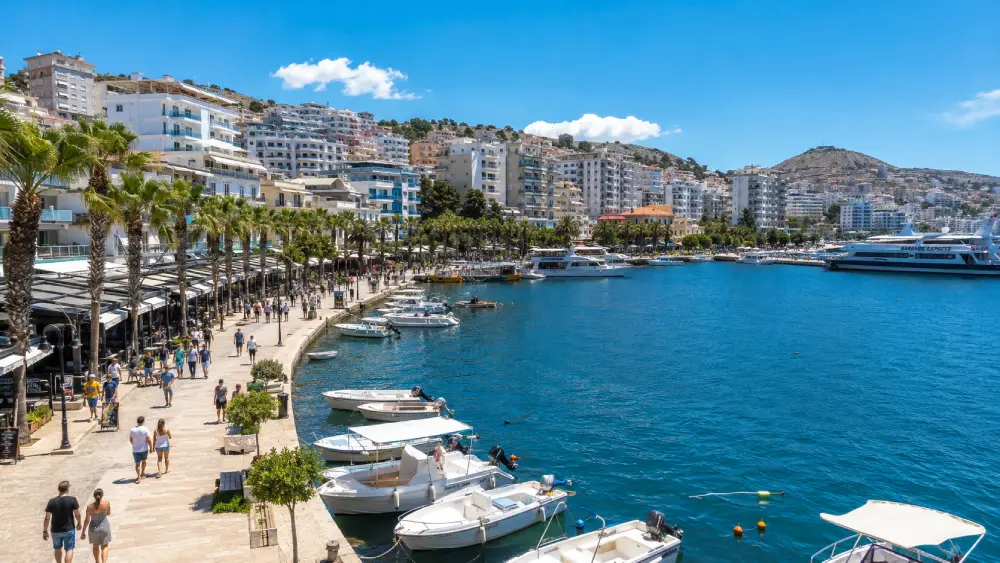 The lively sweeping palm-lined promenade and active harbor of Saranda, Albania.