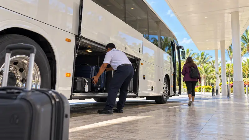 Canc&uacute;n airport coach boarding scene with a traveller and luggage being loaded.