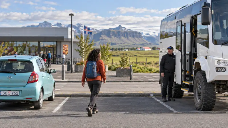 Matkailija jättää pysäköidyn pienikokoisen auton noustakseen Highland Busiin Hellan edustavalla noutoalueella.