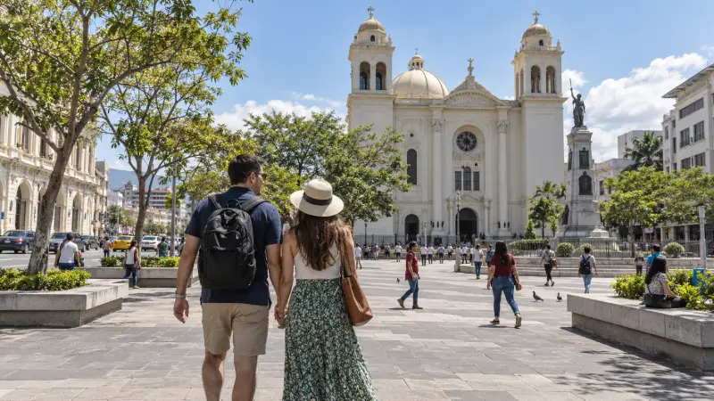 Viajeros caminando por una plaza peatonal cerca de la Catedral Metropolitana, en el Centro Histórico de San Salvador.