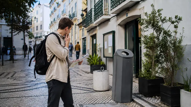 Thoughtful traveler in a Portuguese square representing the difference between drug decriminalization and legalization.