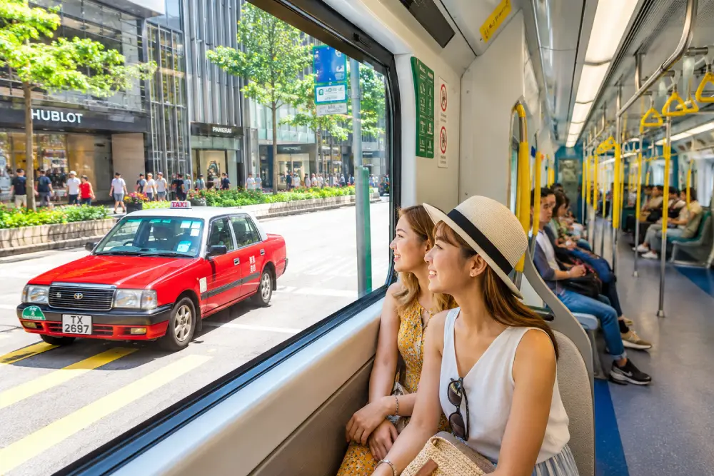 Tourists comfortably using the clean and efficient MTR and red taxis in Hong Kong.