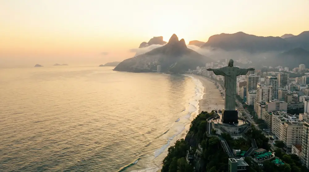 Stunning sunrise over Rio de Janeiro coastline and mountains, marking the end of a carnival night.