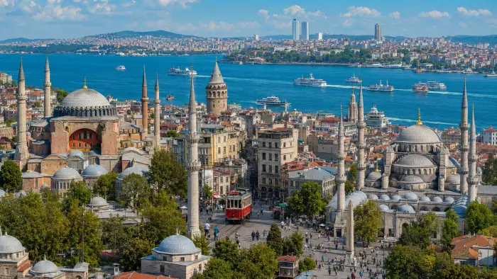 Istanbul neighborhoods with Hagia Sophia, Galata Tower, a red tram, Bosphorus ferries, and the Kadıköy waterfront.
